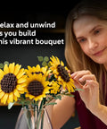 Botanical Sunflower Bouquet Building Kit For Adults 18 Plus DIY Floral Decor Craft For Home Office Bedroom Six Sunflowers In Various Stages Cool Gift For Birthdays Housewarming And Trendy Displays, woman arranging LEGO-style sunflowers in vase