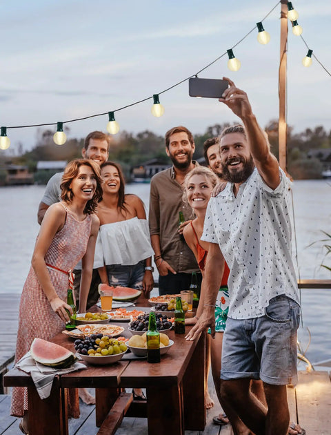 Group enjoying party under Cozy Up Your Patio With 25 Ft Outdoor Globe String Lights 27 Clear G40 Bulbs Plus 2 Spares Perfect For Patio Backyard Cafe Or Indoor Living Room Decor White Wire UL Listed.