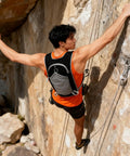 Man rock climbing with Lightweight Hydration Backpack For Outdoor Adventures With Waterproof Phone Pocket And Large Multi Pocket Layout