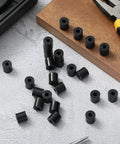 100 Pcs Top Shelf Black Nylon Spacer Washers 1/2 Inch Thick By 1/2 Inch Outer Diameter round washers scattered on table