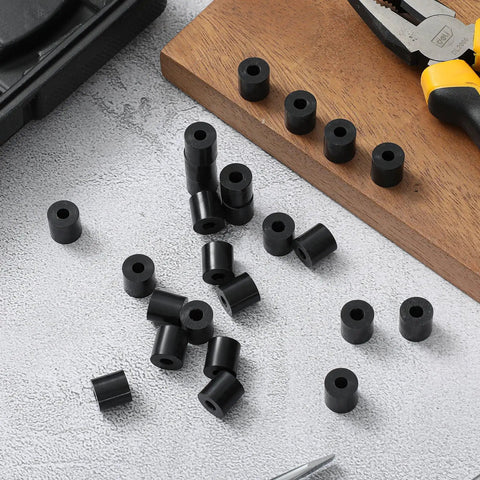 100 Pcs Top Shelf Black Nylon Spacer Washers 1/2 Inch Thick By 1/2 Inch Outer Diameter round washers scattered on table