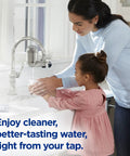 Woman and child using Lead Reducing Faucet Mount Water Filter With Easy Install, 100 Gallon Capacity, Stainless Steel Design for cleaner water