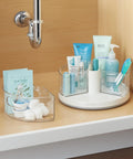 360 Degree Rotating Lazy Susan Organizer With 3 BPA Free Removable Clear Bins With Handles For Kitchen Cabinets Pantry And Bathroom Storage See It All And Grab What You Need Fast, shown under a sink with toiletries and cotton balls.