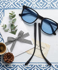 Universal Eyeglass Temple Arms One Pair Sturdy TR90 Replacement Kit With Brass Screws Anti Slip Nose Pads and Precision Tool for Zero Drama Glasses Repair resting beside stylish sunglasses.