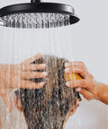 Person washing hair under 9 Inch Round Matte Black Antique Rain Shower Head Replacement With Swivel Ball Stainless Steel Wall Mount High Pressure Rainfall Waterfall Showerhead Vintage Vibe For Modern Bathrooms.