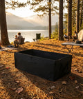 Solid As A Rock Foldable Replacement Liner For Camping Wagons waterproof black liner in a serene camping scene by a lake.