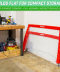 Street Hockey Set With Pop Up Goal Two Wooden Hockey Sticks With Plastic Heads And Two Street Hockey Balls, folded red goal by wall.