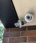 WiFi Floodlight Bulb Camera For Outdoor Security, 1080P Night Vision, mounted under a porch roof, brick wall visible