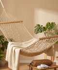 Portable Camping Hammock With Wooden Spreader Bar, AntiRollover Mesh Design in a room with plants, showcasing lightweight design