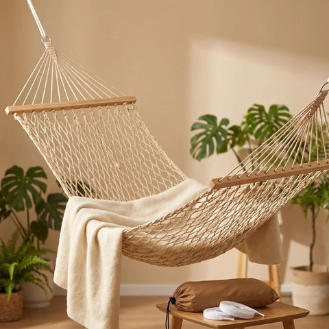 Portable Camping Hammock With Wooden Spreader Bar, AntiRollover Mesh Design in a room with plants, showcasing lightweight design