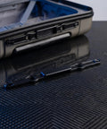Universal Replacement Luggage Handle Push Button Repair Part For Suitcase Trolley Retractable Rod Snap Switch on a carbon fiber surface.