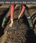 Person using Heavy Duty Metal Garden Rake With 17 Prongs, 17 Inch Wide And 50 Inch Long Handle to clear soil in garden.