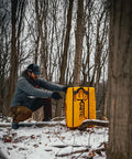 Man with Yellow Jacket Kinetic One Point Zero 65 Pound Portable Field Point Archery Target Bag in snowy forest