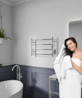 Woman in bathroom with Glow 4 Bar Electric Towel Warmer Rhino Alloy Stainless Steel Polished Chrome Wall Mounted No Fuss 20 Minute Warm
