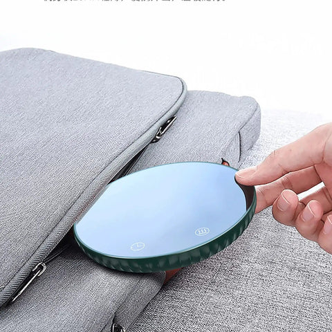 Tempered Glass Top Cup Warmer Pad With Digital Display And Auto Timer To Keep Your Morning Brew Piping Hot And Dodge The Cold Coffee Blues On Busy Weekdays in hand beside a gray bag.