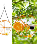 Oriole Bird Feeder For Outdoors Jelly And Oranges, Orange Fruit Feeder With Glass And Metal Build, shown in garden setting