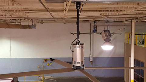 Heavy Duty Twenty Foot Industrial Ceiling Fan Using High Volume Low Speed Technology mounted in a warehouse setting.