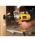 Corded Drill Powerhouse With 1/2-Inch Chuck, 10 Amp Motor, Mid Handle Grip in use for drilling wood at construction site