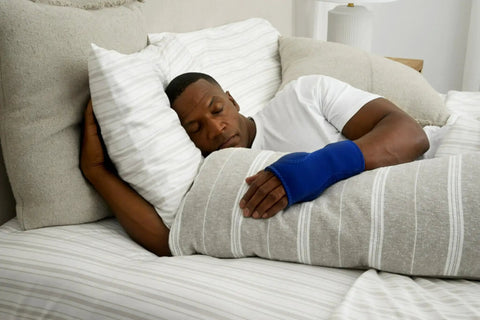 Person sleeping with Night Wrist Support For Carpal Tunnel Relief, Left Or Right, Adjustable, Breathable Sleeve in blue.