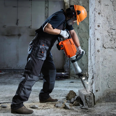 Worker using Beefy Heavy Duty Demolition Jack Hammer 2200W Electric Concrete Breaker With 1350 BPM on concrete wall