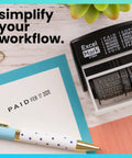 Workhorse Self Inking Date Stamp With Twelve Rotatable Bands For Paid Received Posted Scanned Shipped Void Verified And Full Year Setup Built To Last For Busy Office Crews on a desk with stationery.