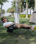 Man relaxing on Comfy Reclining Beach Chair With Adjustable Backrest From Ninety To One Hundred Thirty Five Degrees, gray with trees in background