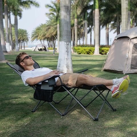 Man relaxing on Comfy Reclining Beach Chair With Adjustable Backrest From Ninety To One Hundred Thirty Five Degrees, gray with trees in background