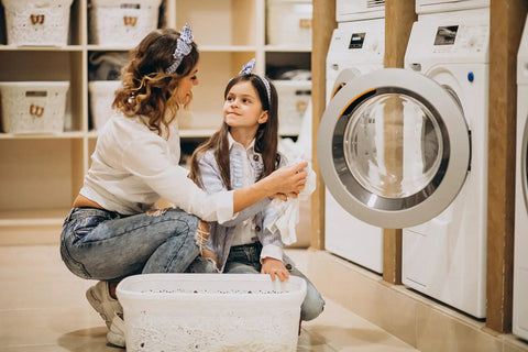 Mother and daughter doing laundry with a washing machine, focusing on family bonding and home chores.