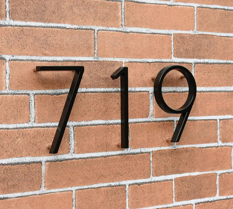 Set of three 5-inch black stainless steel floating house numbers 7, 1, 9 with nail kit on brick wall