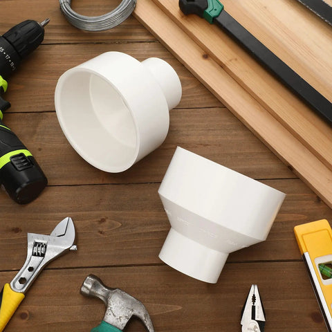 2 Pack 4 Inch By 2 Inch PVC Reducer Coupling Adapter Socket To Socket Fittings with tools on wooden surface