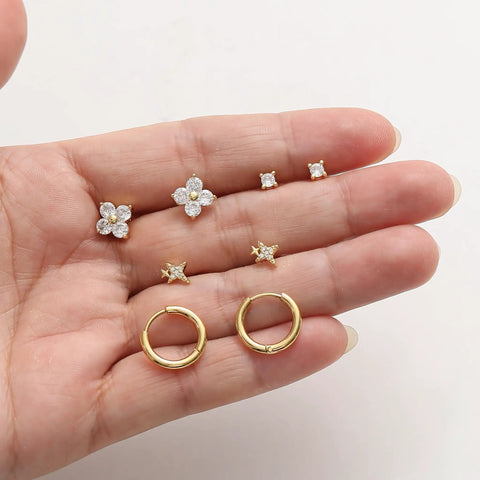 Gold Stud Earrings Set For Women With Nine Pairs Of CZ Flower, Ball, And Star Huggie Hoops For Multiple Piercings, Flat Back Cartilage Tragus Earrings, Stacks, Gold Silver Plated, Everyday Shine. Close-up of gold CZ flower, star, and hoop studs.