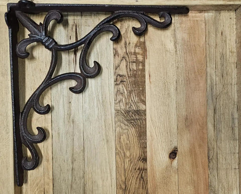 Heavy Duty Cast Iron Shelf Bracket Set With Ornate Fleur De Lis Pattern 10 By 10 Inch Shelf Supports For Sturdy Wall Shelves Classic Decorative Metal Brackets In Satin Brown Finish 8 Count shown against wood background