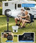 No Hose Needed Misting Fan With Built In Pump 12 Inch Portable Outdoor Oscillating Pedestal Fan With Remote And Timer Spray Mist System For Patio Or Bedroom 30000mAh Rechargeable Battery Keeps Ya Cool All Day, shown with two people outdoors by a motorhome.