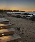 Beachside stairs illuminated by Ledme 120V Horizontal Indoor Outdoor Step And Wall Light With Built In 3000K LED White Finish Energy Efficient Landscape Fixture For Stairs Walls And Walkways Easy 2x4 Junction Box Install at sunset.