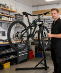 Person using Bike Repair Stand With 360 Degree Rotating Clamp Holds Up To 110 Lbs Adjustable Jaws 1 To 1.5 Inches Workstand