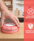 120pc Fire Sprinkler Dust Guards That Keep Grit Out Of Your Gear Heavy Duty Elastic Caps covering a smoke detector with a hand applying it.