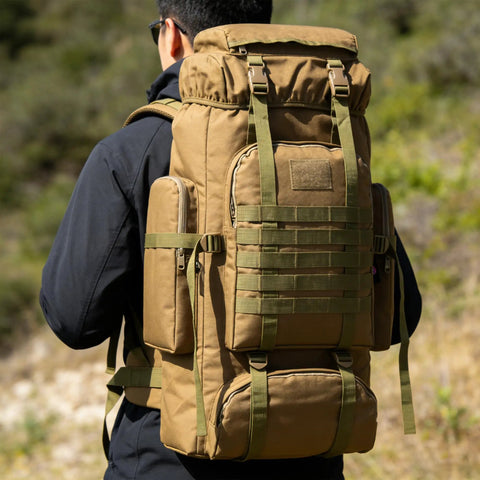 Back view of person wearing Beefy 70 Liter And 100 Liter Hiking Backpack For Men, Military Style Rucksack with MOLLE in outdoor setting
