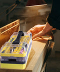 Person using 619 Piece Rotary Tool Accessories Kit With One Eighth Inch Shanks for a woodworking project under a lamp