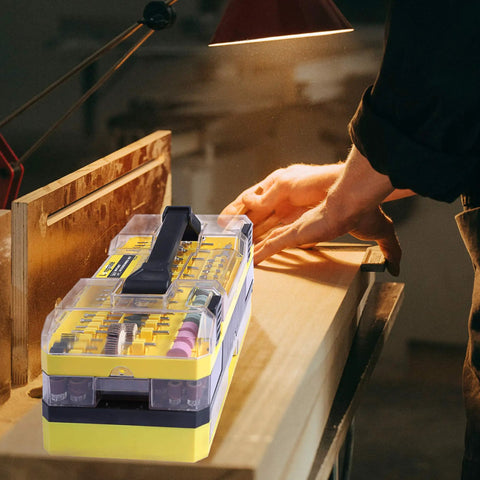 Person using 619 Piece Rotary Tool Accessories Kit With One Eighth Inch Shanks for a woodworking project under a lamp