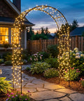 Outdoor Flower Garden Arch Trellis 7.8 Ft High By 4.6 Ft Wide Metal Garden Pergola Arbor with lights in a yard at dusk