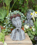 Face Head Planter Pot For Succulents And Small Plants With Drainage Hole on wooden surface surrounded by garden foliage
