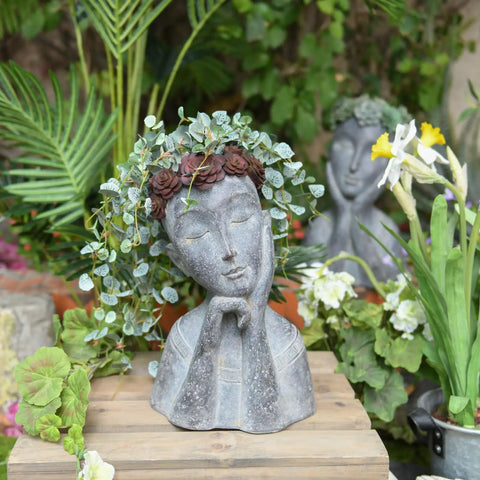 Face Head Planter Pot For Succulents And Small Plants With Drainage Hole on wooden surface surrounded by garden foliage