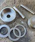 Total Game Changer Coin Ring Punch Set With Four Sleek Self Centering Tools on a workbench with metal circular blanks.
