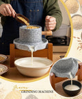 Hand-cranked stone grain mill grinder for home use with solid wood base, grinding grains into fresh flour for bread and tortillas.