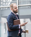 Professional man holding Career Game Changer Business Padfolio With Heavy Duty Zipper Closure Crafted From Smooth Pu Vegan Leather.