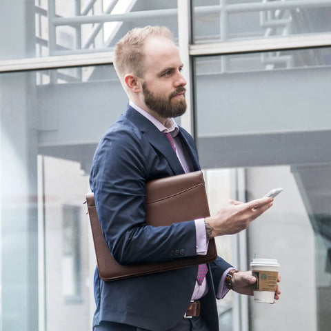 Professional man holding Career Game Changer Business Padfolio With Heavy Duty Zipper Closure Crafted From Smooth Pu Vegan Leather.