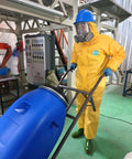 Rugged Chemical Resistant Coveralls With Integrated Boots And Hood For Straight Up Reliable Full Body Safety Engineered Durable Sealed Polyethylene Coated Suit Size S worn by worker handling equipment.