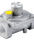 Gas regulator with metal body, yellow safety cap, and top adjustment knob; inlet/outlet ports visible