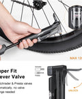 Hands using 120 PSI tire pump from Bike Phone Mount Bag With 120 PSI Tire Pump And 14 In 1 Multitool Tire Lever All In One Trailside Repair Kit.