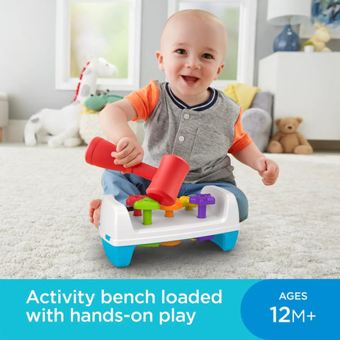 Baby playing with Toddler Tap And Turn Tool Bench Play Set For Tiny Tot Builders, Kid Friendly, A Two Sided Construction Toy With Five Colorful Shape Pegs, Easy Grasp Hammer, Flip For Double Play, Teaches Colors And Shapes And Builds Fine Motor Skills, Fisher-Price indoors